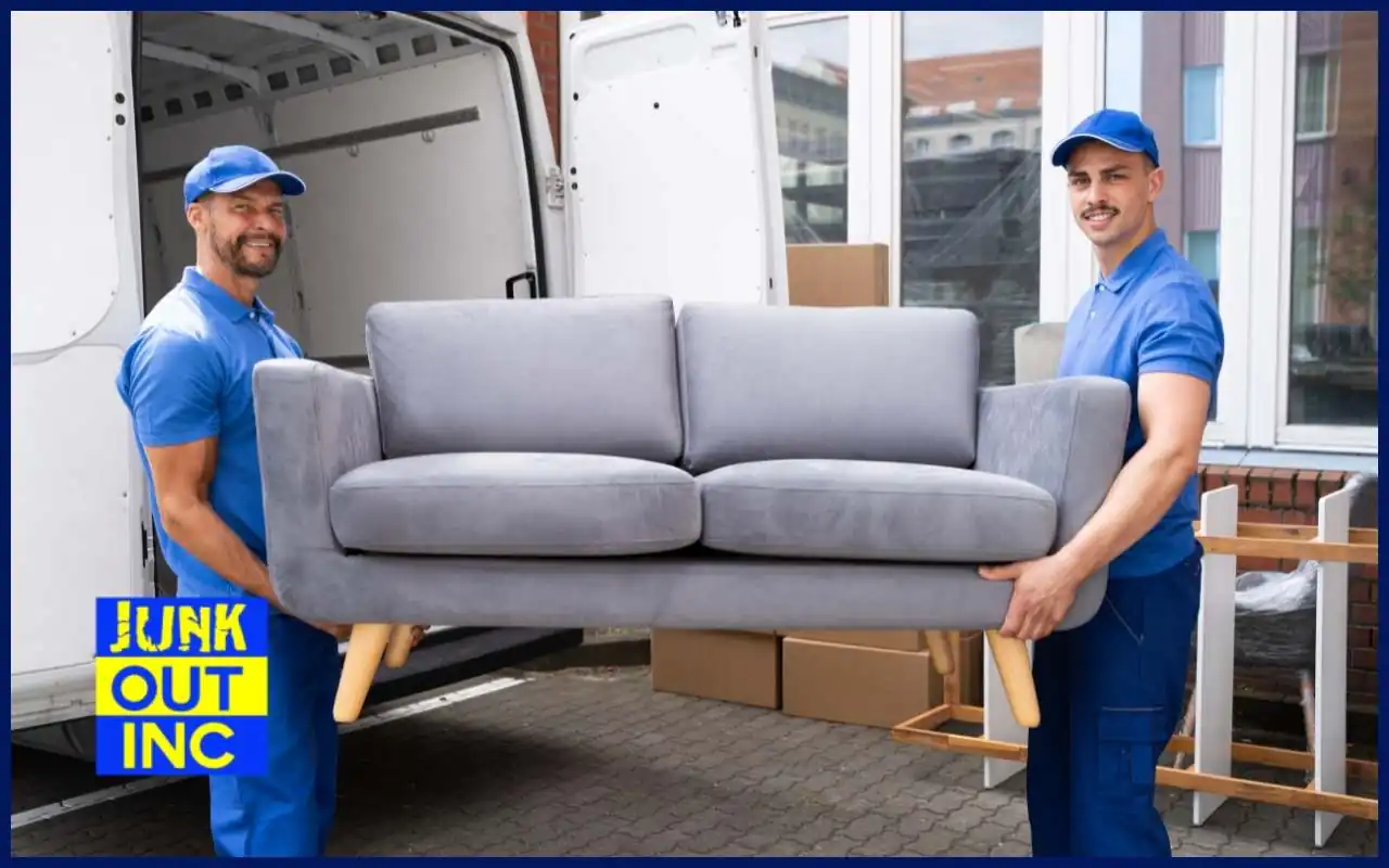 Professional furniture movers safely lifting a couch